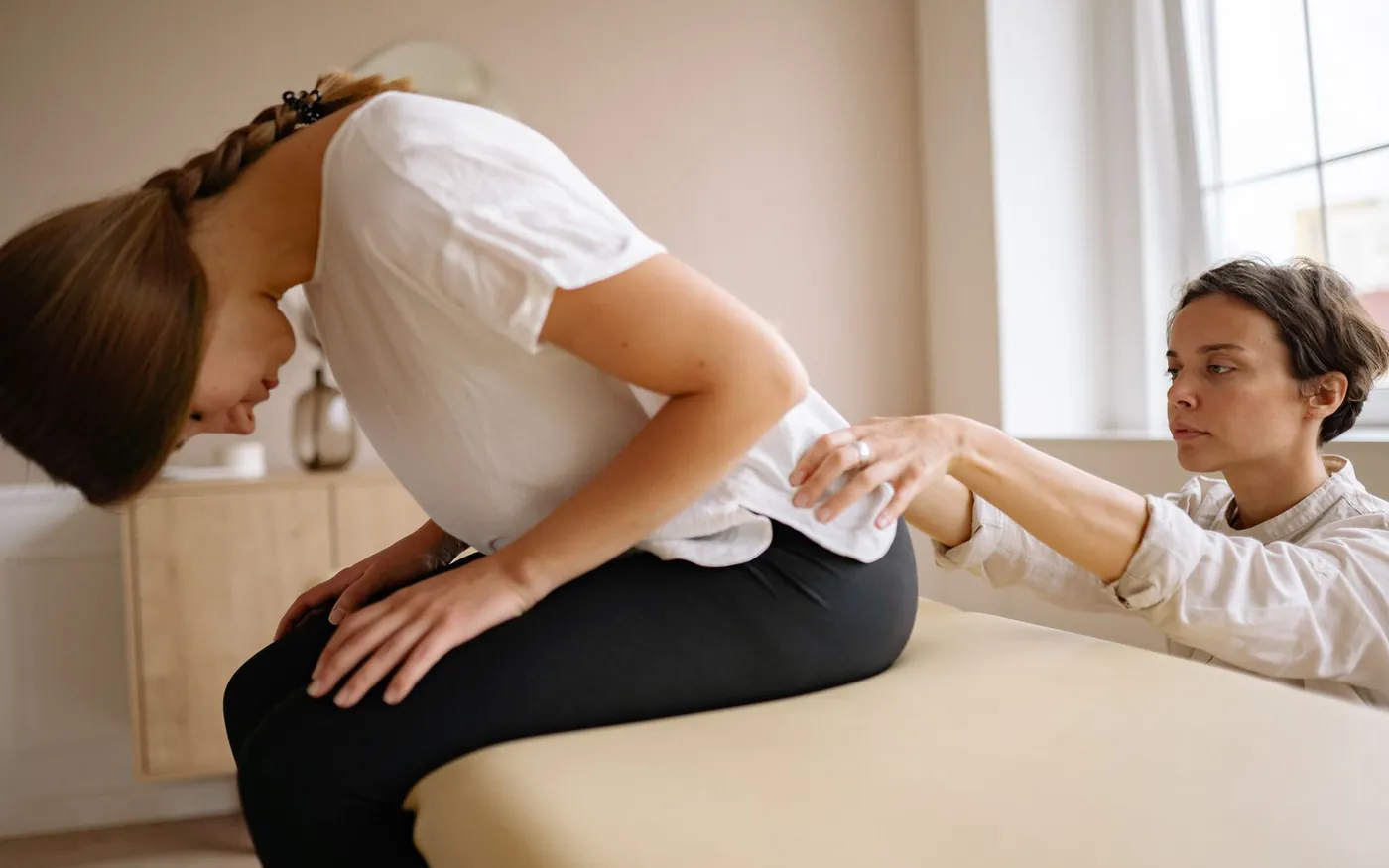 Fisioterapeuta orientando paciente em exercício de reabilitação da coluna